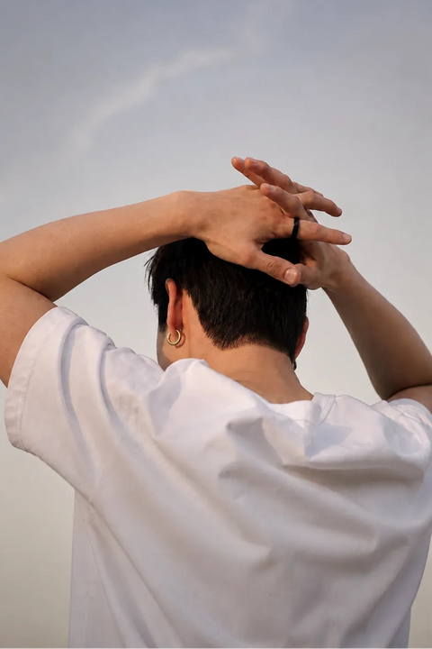 Person in white shirt adjusting hair, viewed from behind, wearing a black ring | Smartring PH