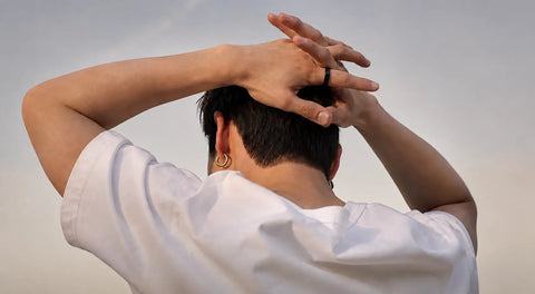Person in white shirt adjusting hair, viewed from behind, wearing a black ring | Smartring PH