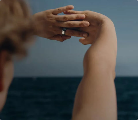 Person wearing an smart ring while relaxing outdoors by the sea | Smartphone PH
