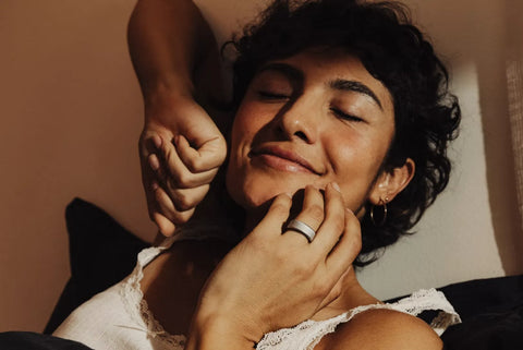 Woman smiles with eyes closed as someone gently touches her face while resting | Smartring PH